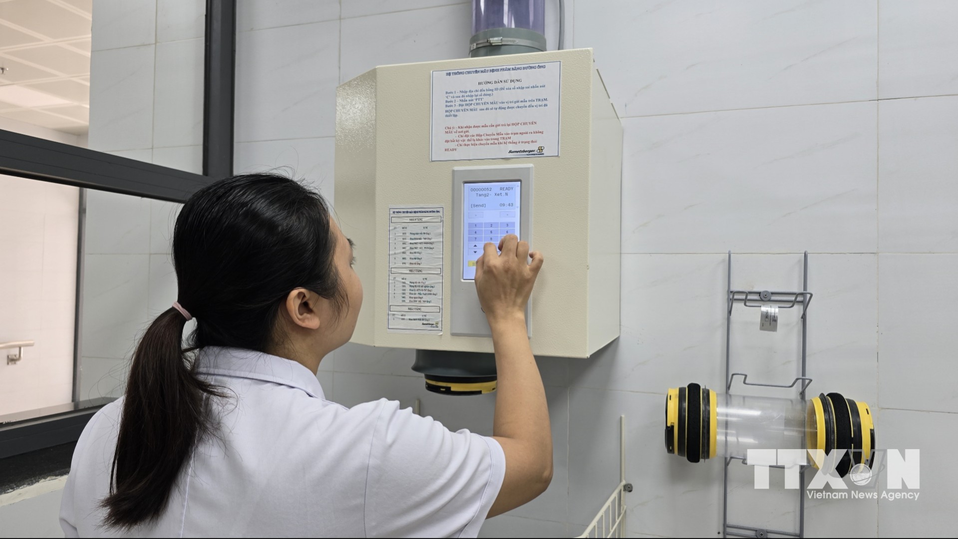 Nếu như trước đây, điều dưỡng phải mất từ 5 đến 10 phút đi bộ để chuyển mẫu bệnh phẩm xuống khoa xét nghiệm, thì hiện nay hệ thống ống chuyển tự động rút ngắn thời gian này xuống chưa đến 1 phút. (Ảnh: Thanh Vân/TTXVN)